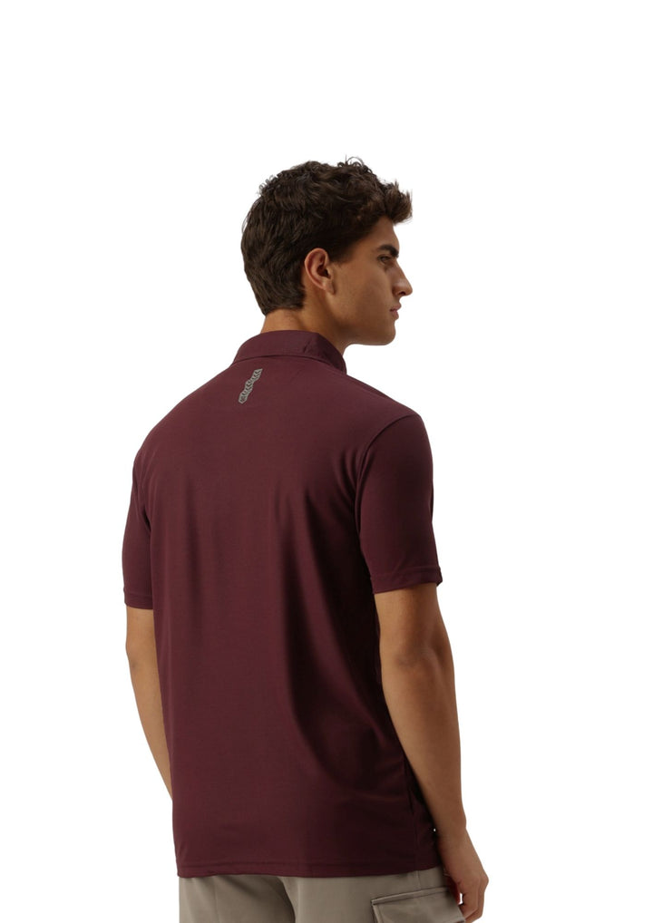 A man wearing a short-sleeve polo shirt in maroon, shown from a side-back angle against a plain white background.