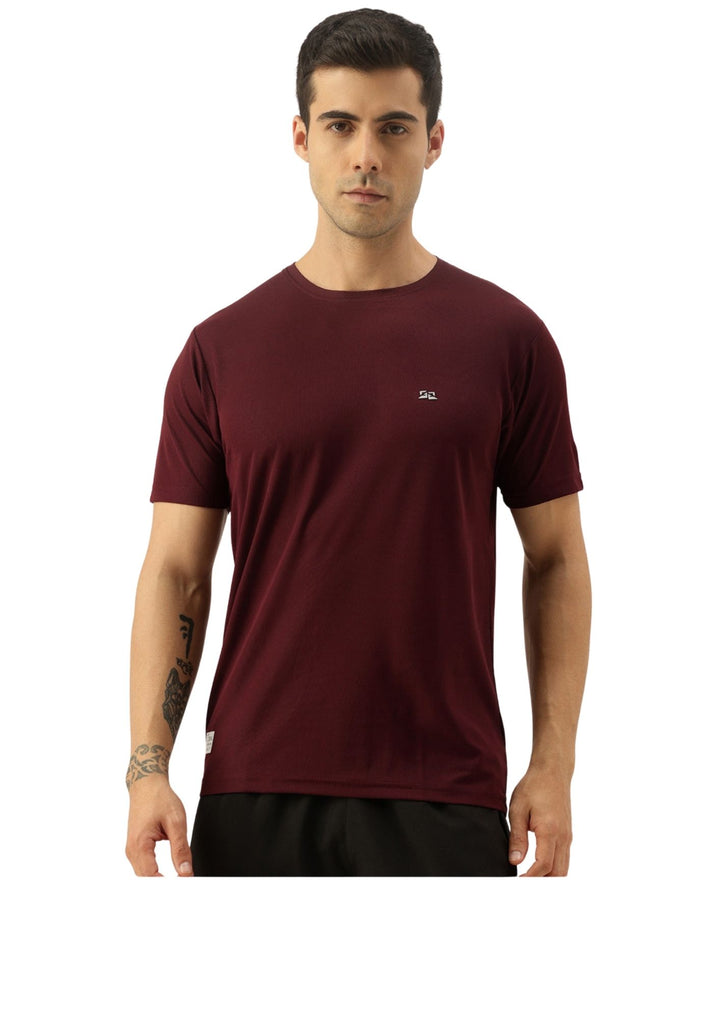 A man wearing a short-sleeve crew-neck athletic t-shirt in maroon with a small white logo on the left chest, paired with black shorts, against a plain white background.