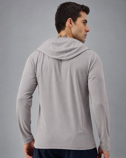 A man wearing a light gray long-sleeve athletic hoodie, shown from the back and side profile against a solid gray studio background.