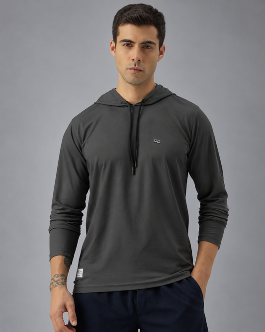 A man wearing a dark gray long-sleeve athletic hoodie with a small white chest logo, photographed against a solid grey background.