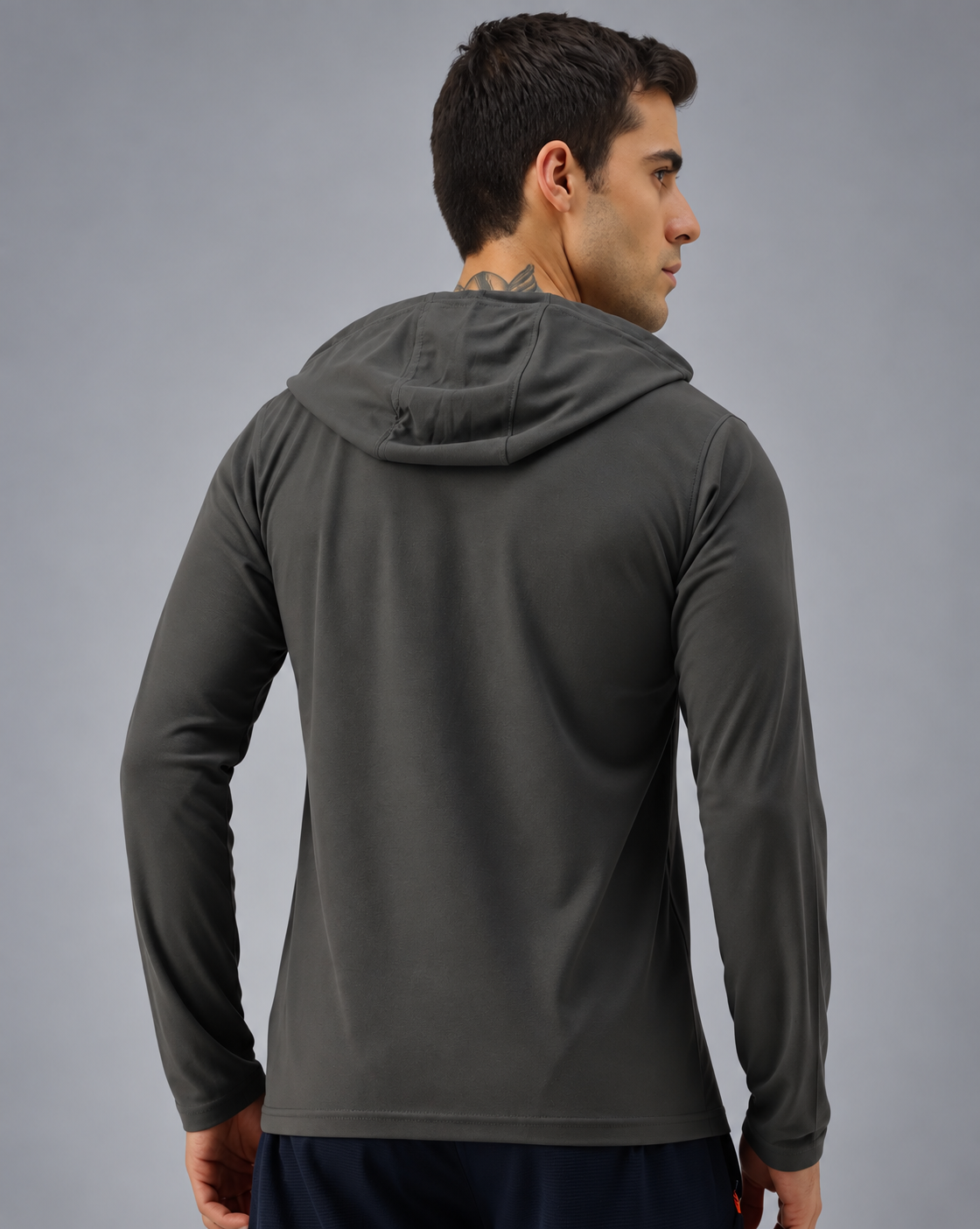 A man wearing a dark gray long-sleeve athletic hoodie, shown from the back and side against a neutral gray studio background.